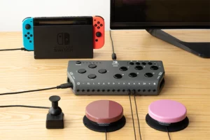 A Nintendo Switch gaming system hooked up to a TV and controller with variou inputs including two large red and pink buttons